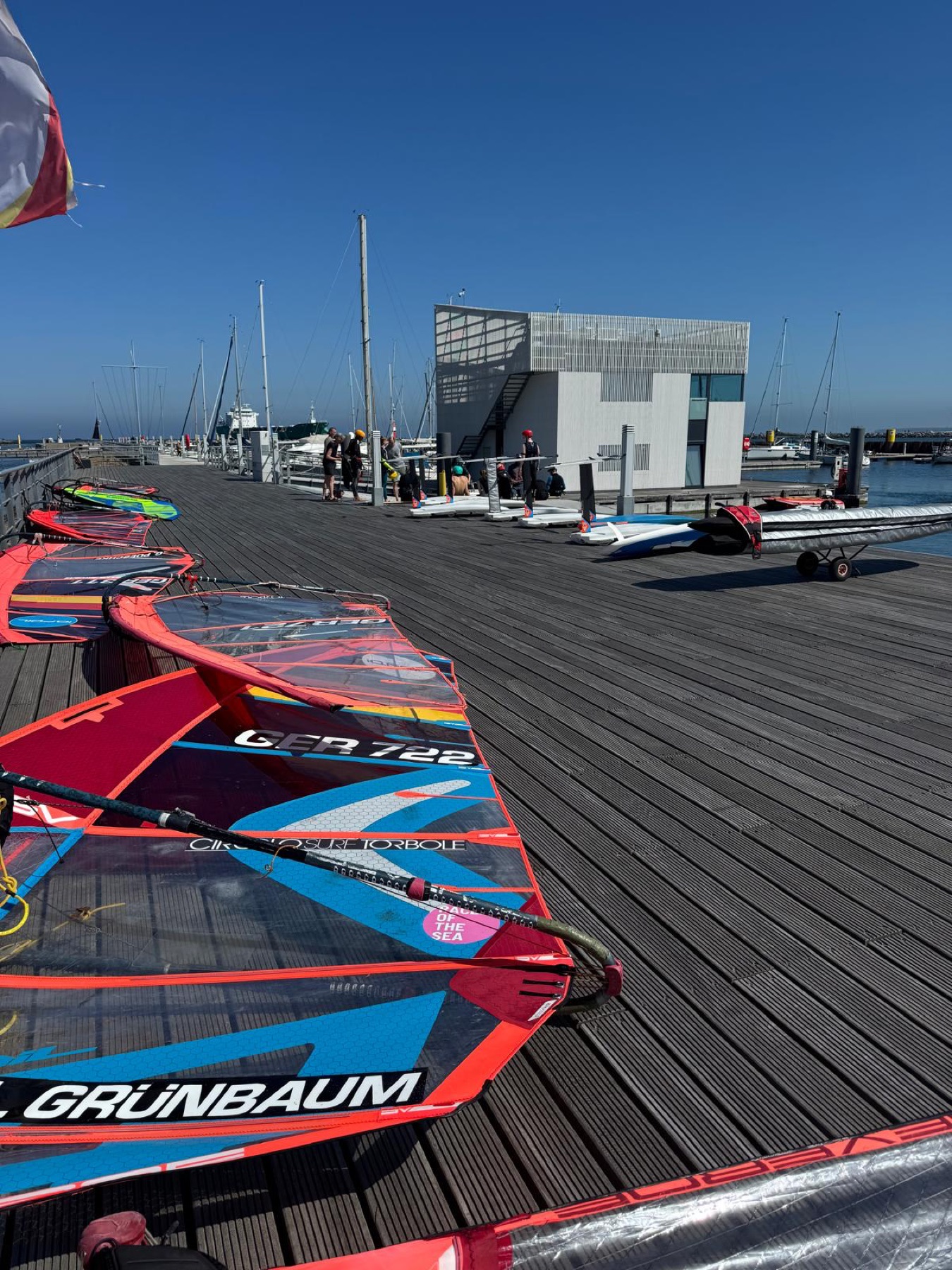Sails and iQFOiL equipment lined up on the dock before training